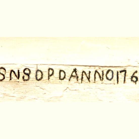 Farvefoto af detalje: Bjælke med opførelsesåret indmuret i udlængen.