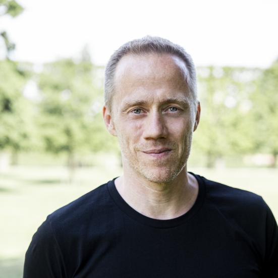Foto af Henrik Duer udenfor med grønt i baggrunden