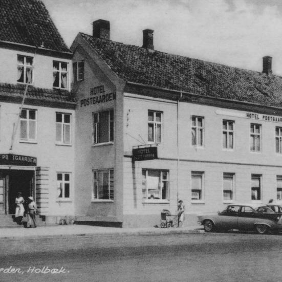 Sort-hvid foto af Hotel Postgården med parkerede biler foran.