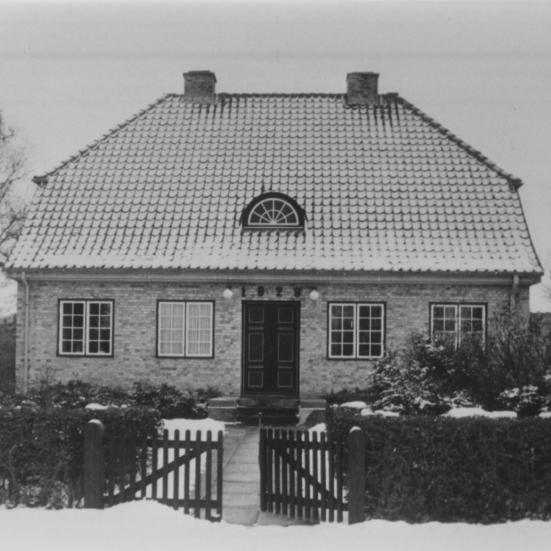 Sort-hvid foto af villa i vinterlandskab.