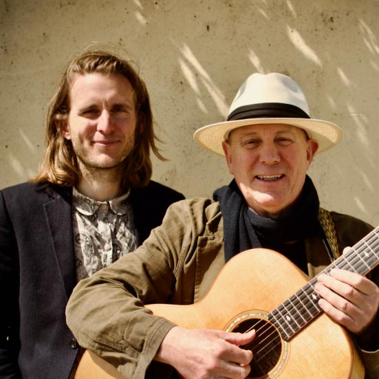 Foto af far og søn op af en mur med guitar en solskinsdag