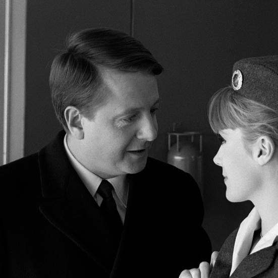 mand, hovedrollen, i samtale med stewardesse