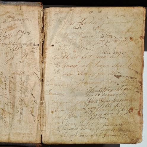 Farvefoto af sider i en bog med indskrifter.