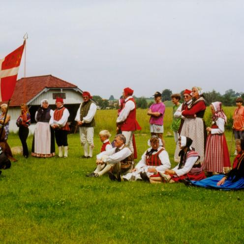 Folk i folkedragt i andelslandsbyen Nyvang.