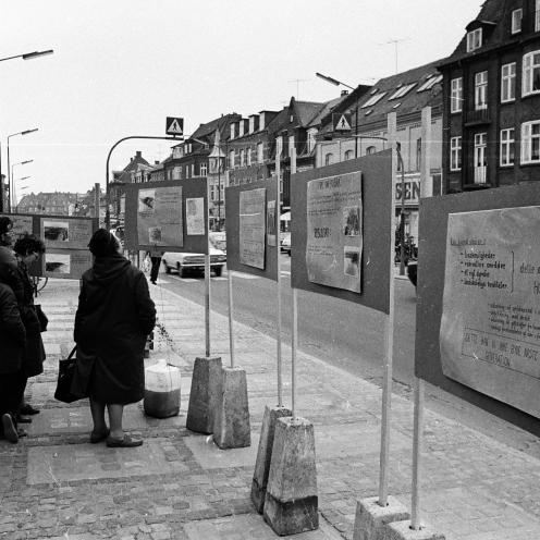 Sort-hvid foto af plancher opstillet på Ahlgade og folk, der læser dem.