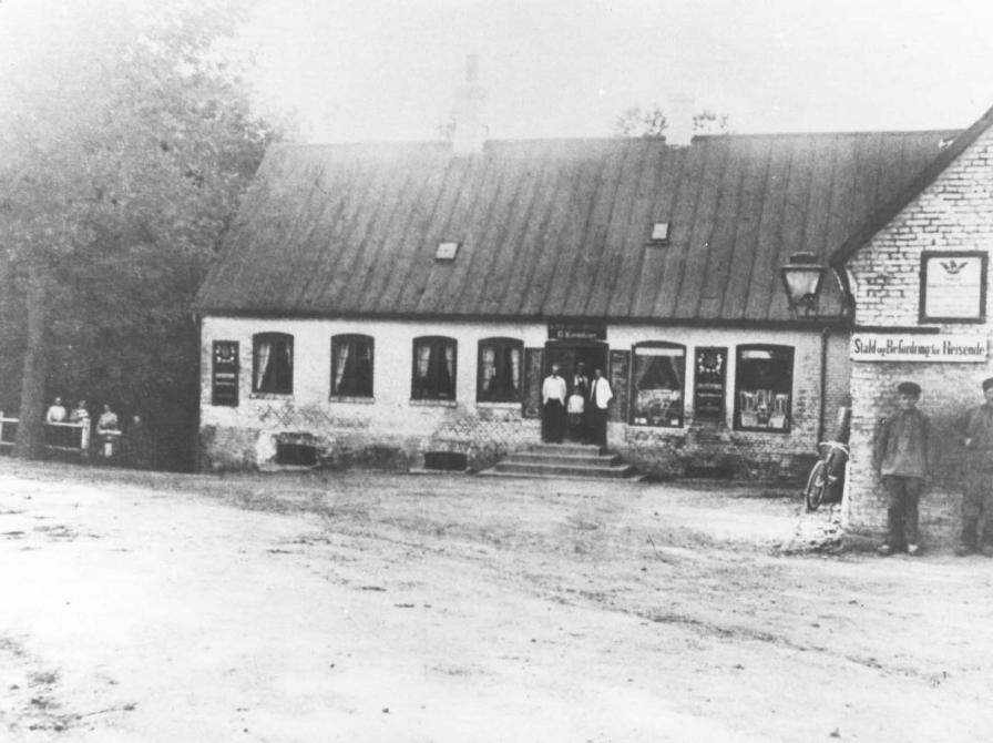 Sort-hvid foto: Den første købmandsgård på Tølløsevej 2 set fra gaden.