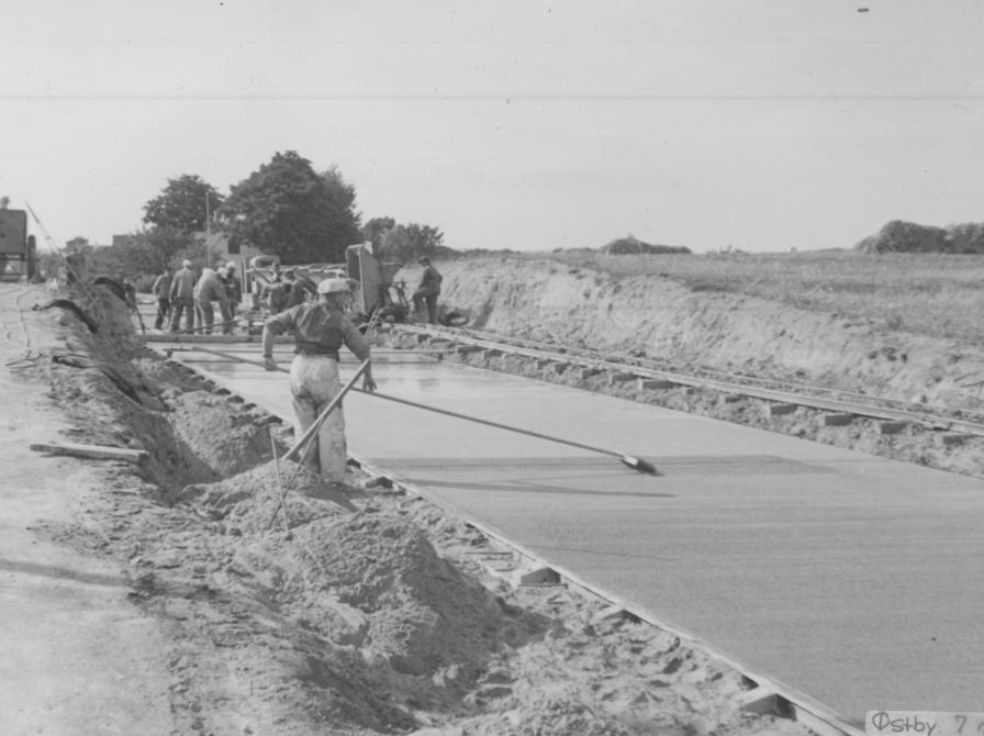 Sort-hvid foto af arbejdere, der er ved at anlægge en vej.