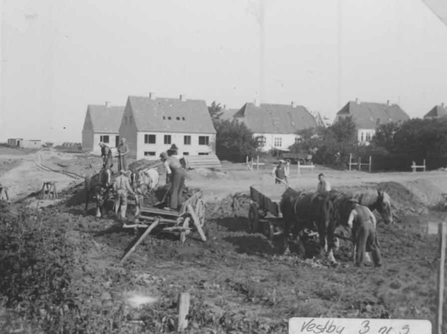 Sort-hvid foto af arbejdende mænd med hestevogne.