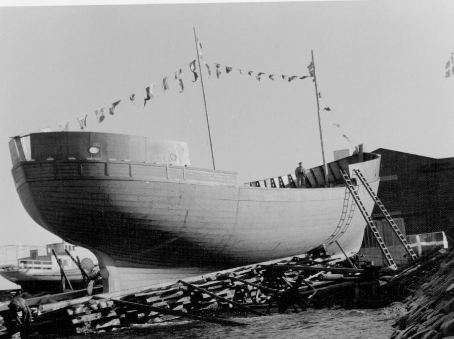 Sort-hvid foto af træskroget af et skib.