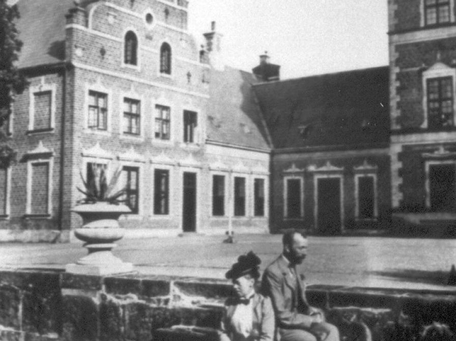 Greven og grevinden sidder på en trappe foran slottet i Tølløse Slots park.