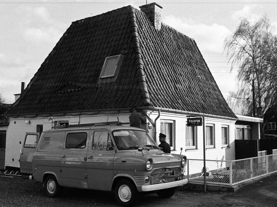 Gislinge Telefoncentral. En servicevogn holder foran huset og to teknikere arbejder.