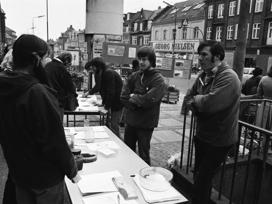 Sort-hvid foto af opstillede borde på Ahlgade med folk i samtale omkring.