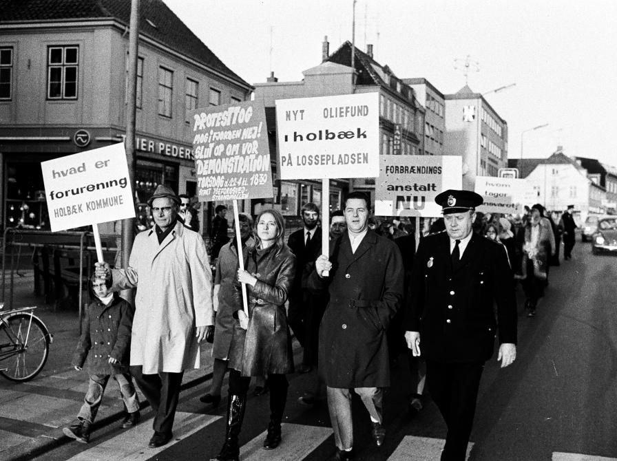 Sort-hvid foto af demonstrationstog med skilte.
